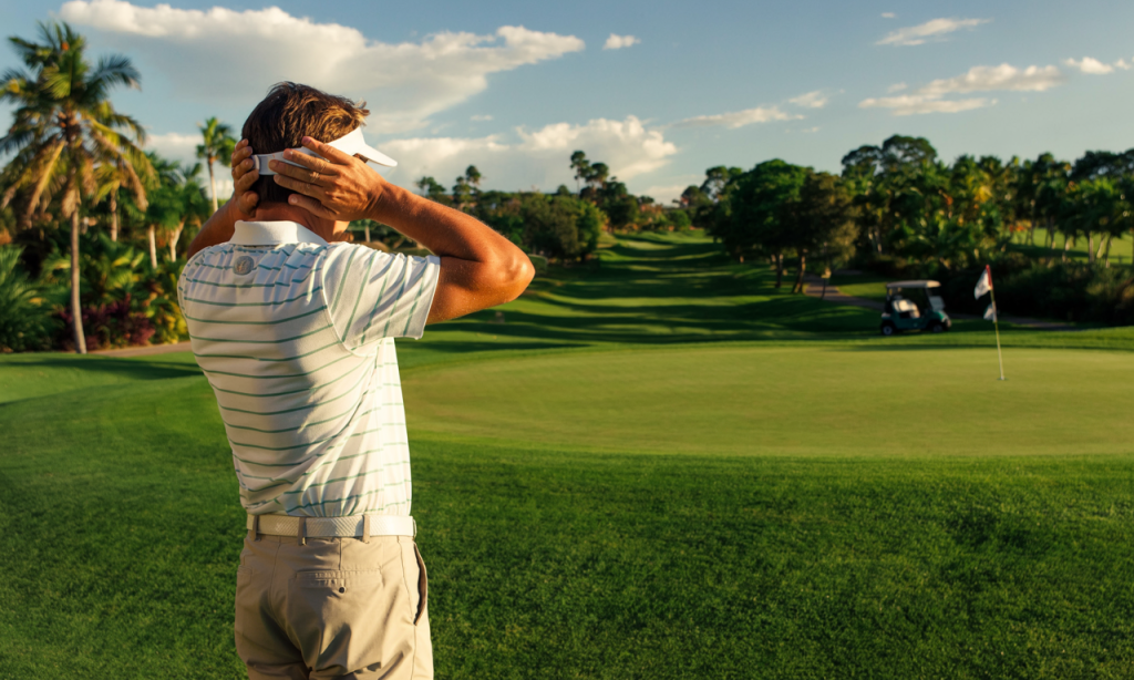 Frustrated golfer watching the green from behind, symbolizing Common Mental Mistakes That Ruin Your Golf Round.